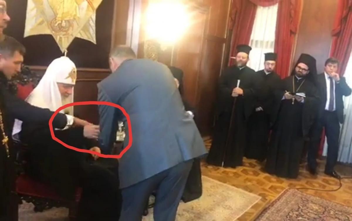 Представитель службы безопасности российской делегации огрызается, поскольку российский патриарх Кирилл, кажется, достает «неправильный» стакан из подноса